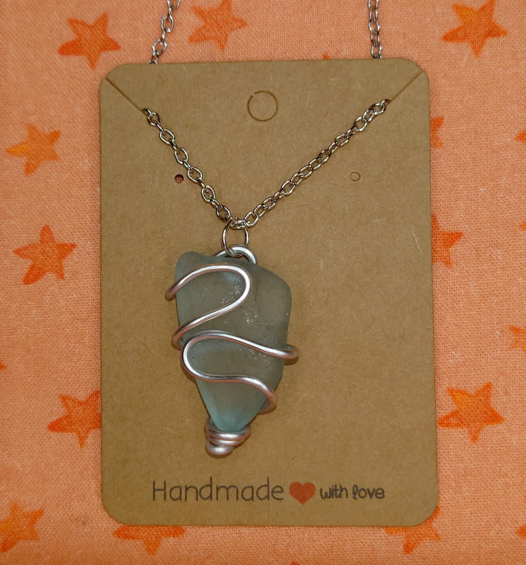 Wire wrapped turquoise sea glass pendant in silver setting.