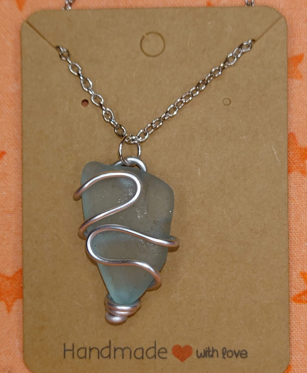 Wire wrapped turquoise sea glass pendant in silver setting.