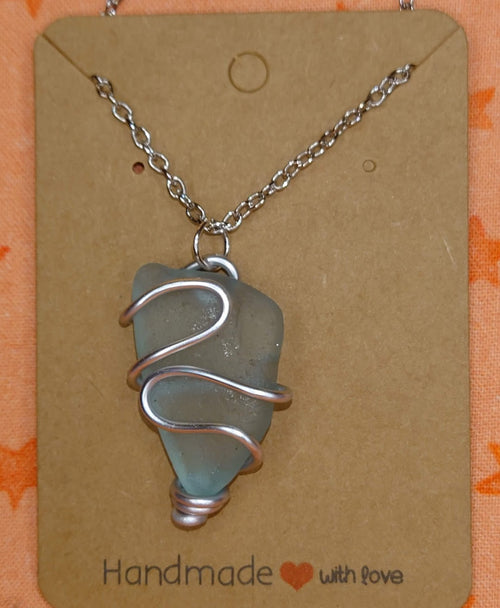 Wire wrapped turquoise sea glass pendant in silver setting.